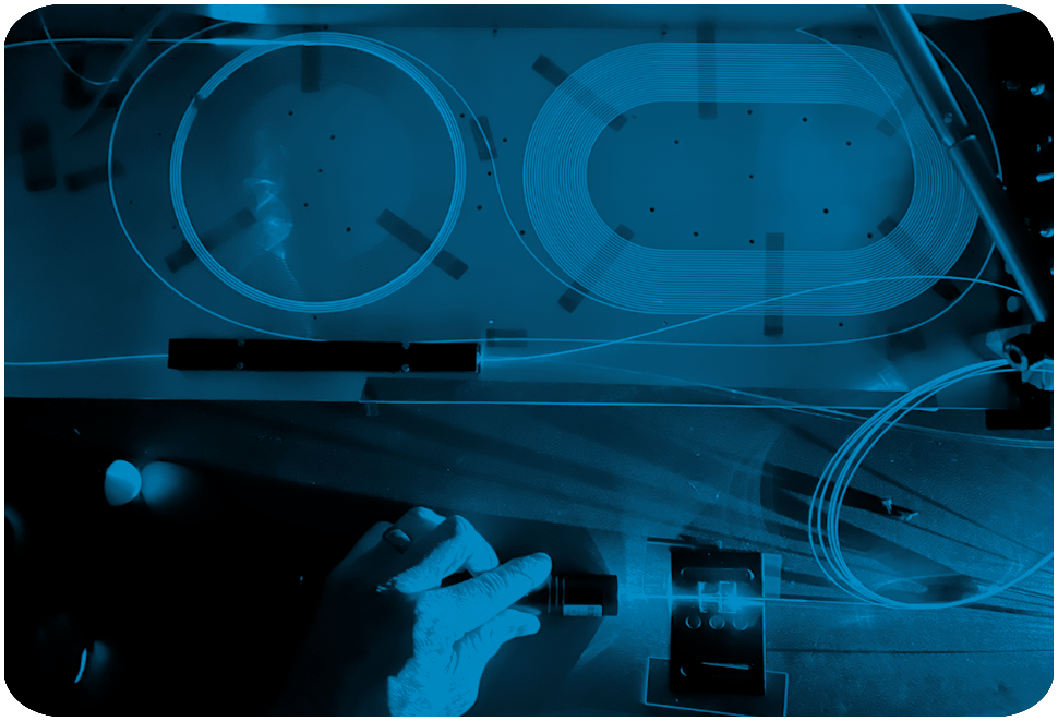 Optical Engines technician working with fiber laser components in a photonics lab