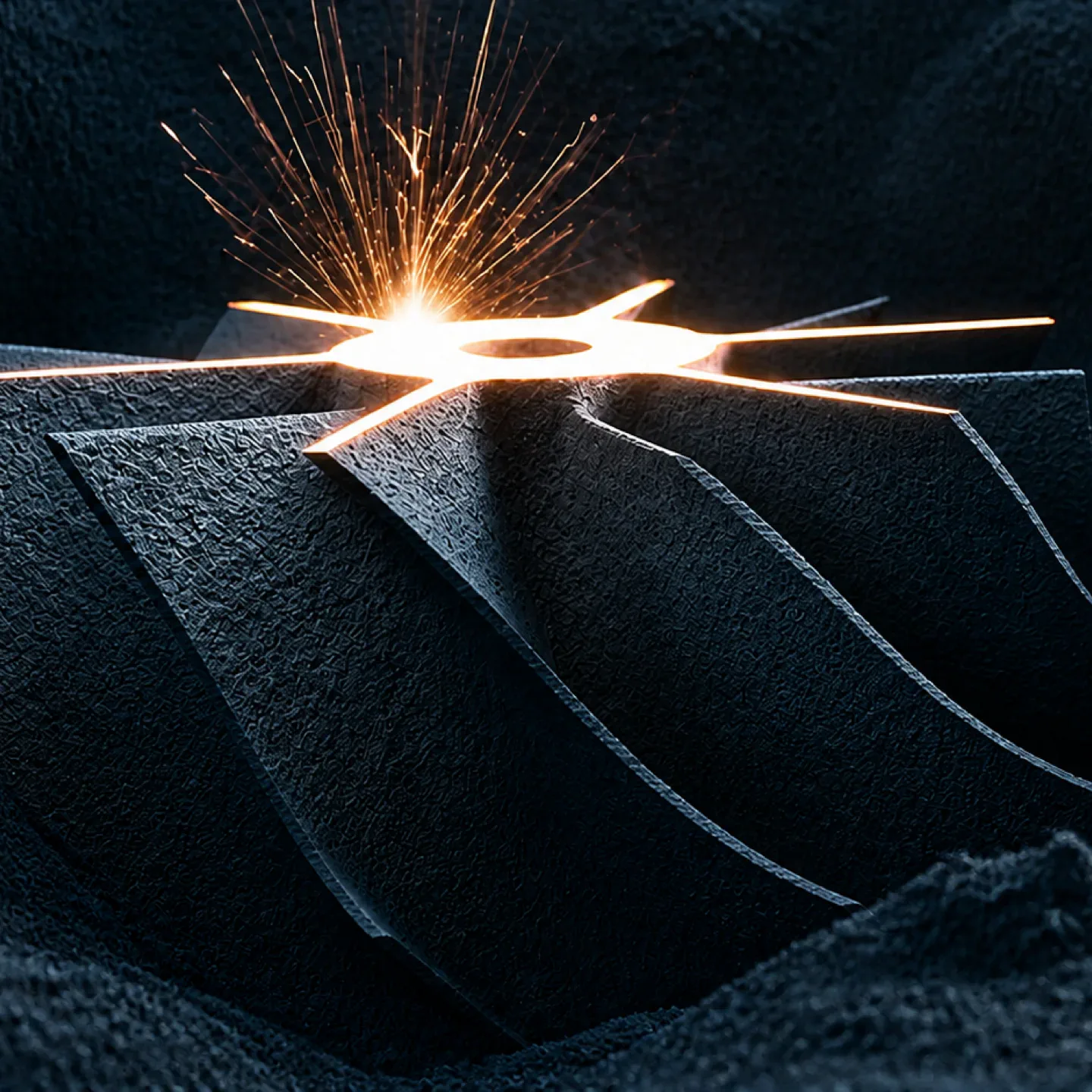 Representative close-up of laser powder bed fusion melting metal powder to build a dark metal component.