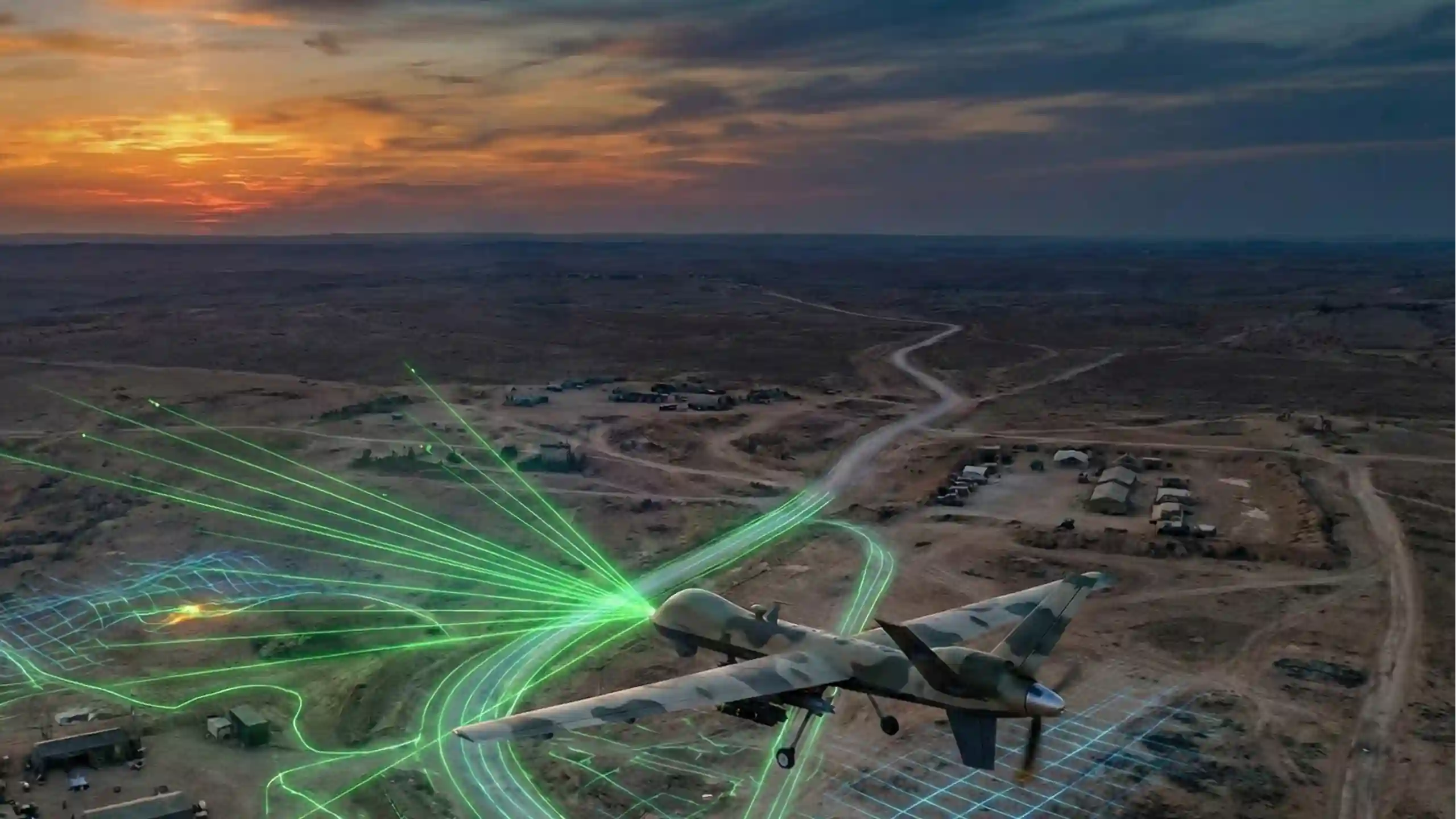 Aerial view of a desert defense test range at sunset with an unmanned aircraft and green and blue target-illumination paths across the ground.